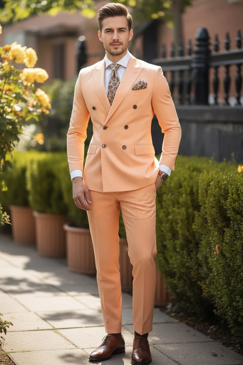 Man wearing a peach suit with a patterned tie and pocket square, standing outdoors.