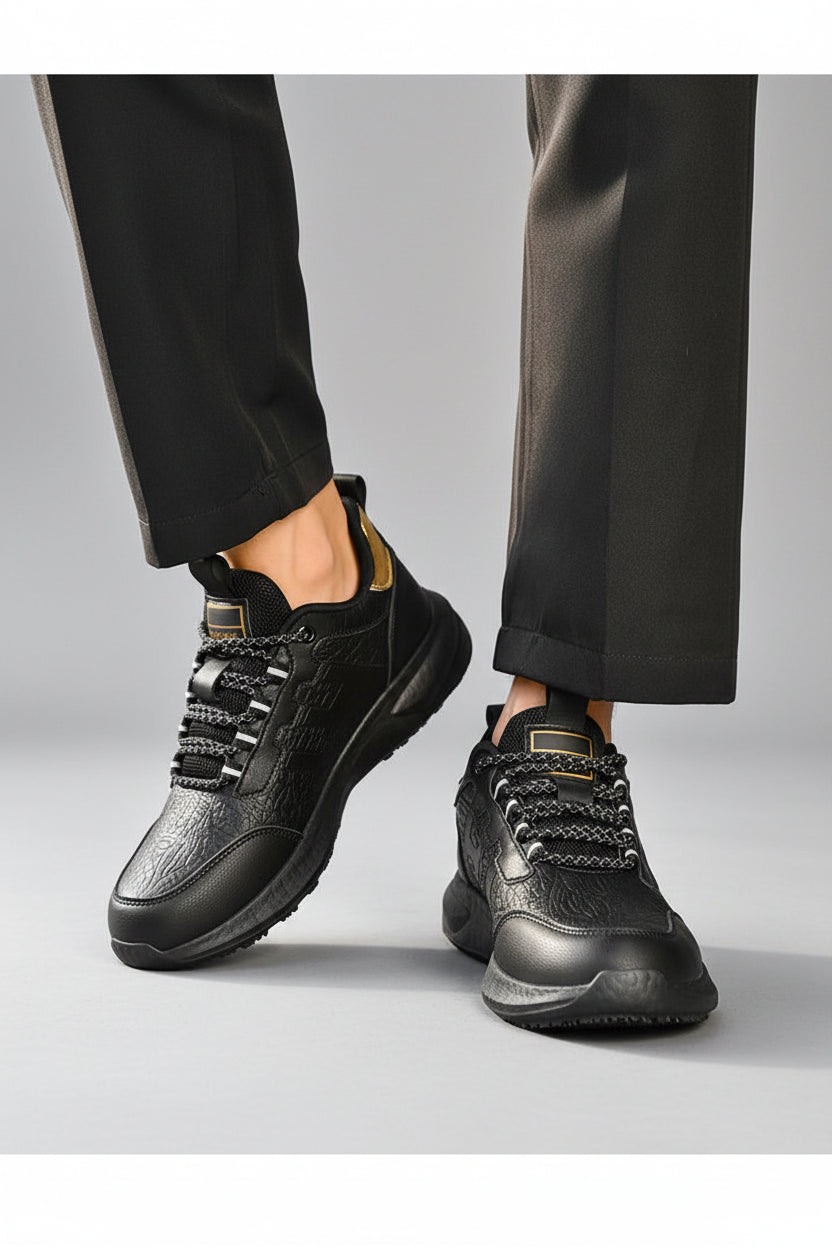 Black hiking shoes worn by a person on a wooden floor.