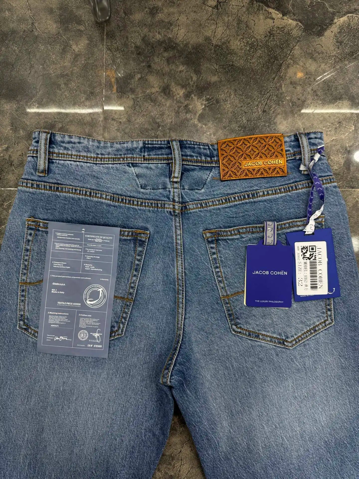 Blue jeans with tags on a concrete floor