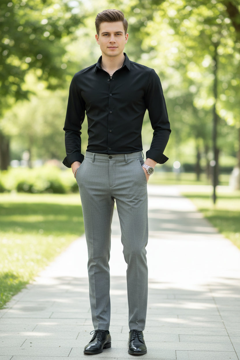 Man wearing a black dress shirt and gray pants in a clothing store setting.