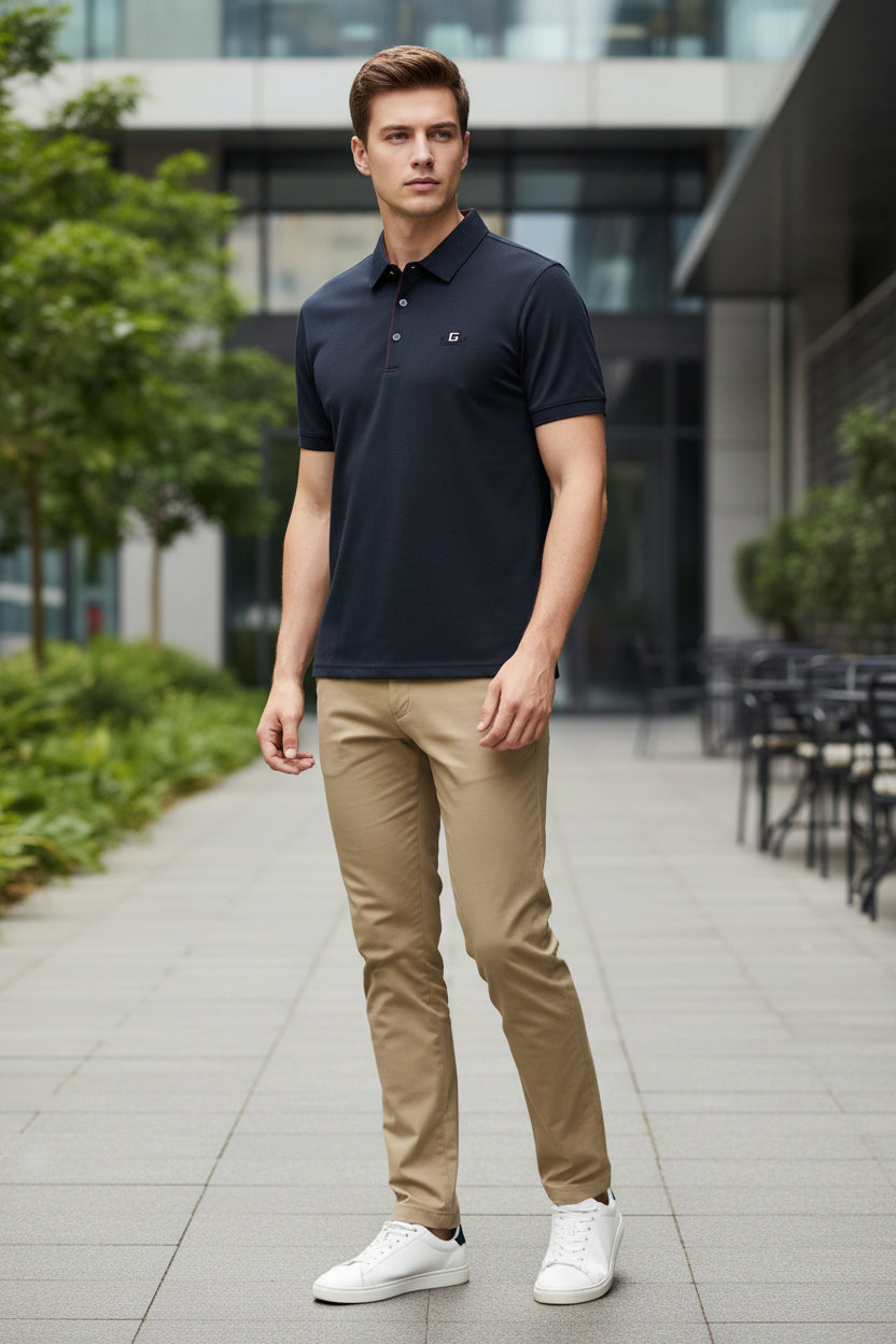 Dark blue shirt with red stitching on a hanger, held by a hand.
