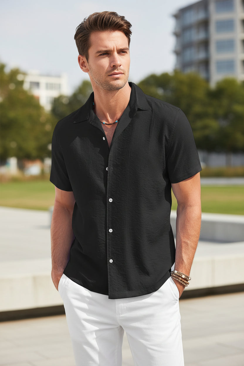Man wearing a black short-sleeve button-up shirt outside